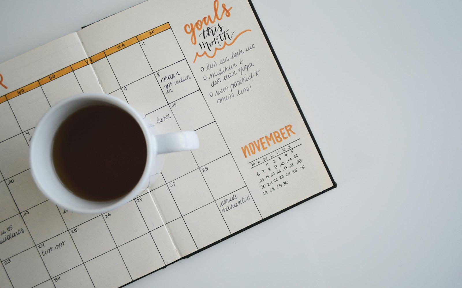 A calendar and coffee on a desk at the start of the day