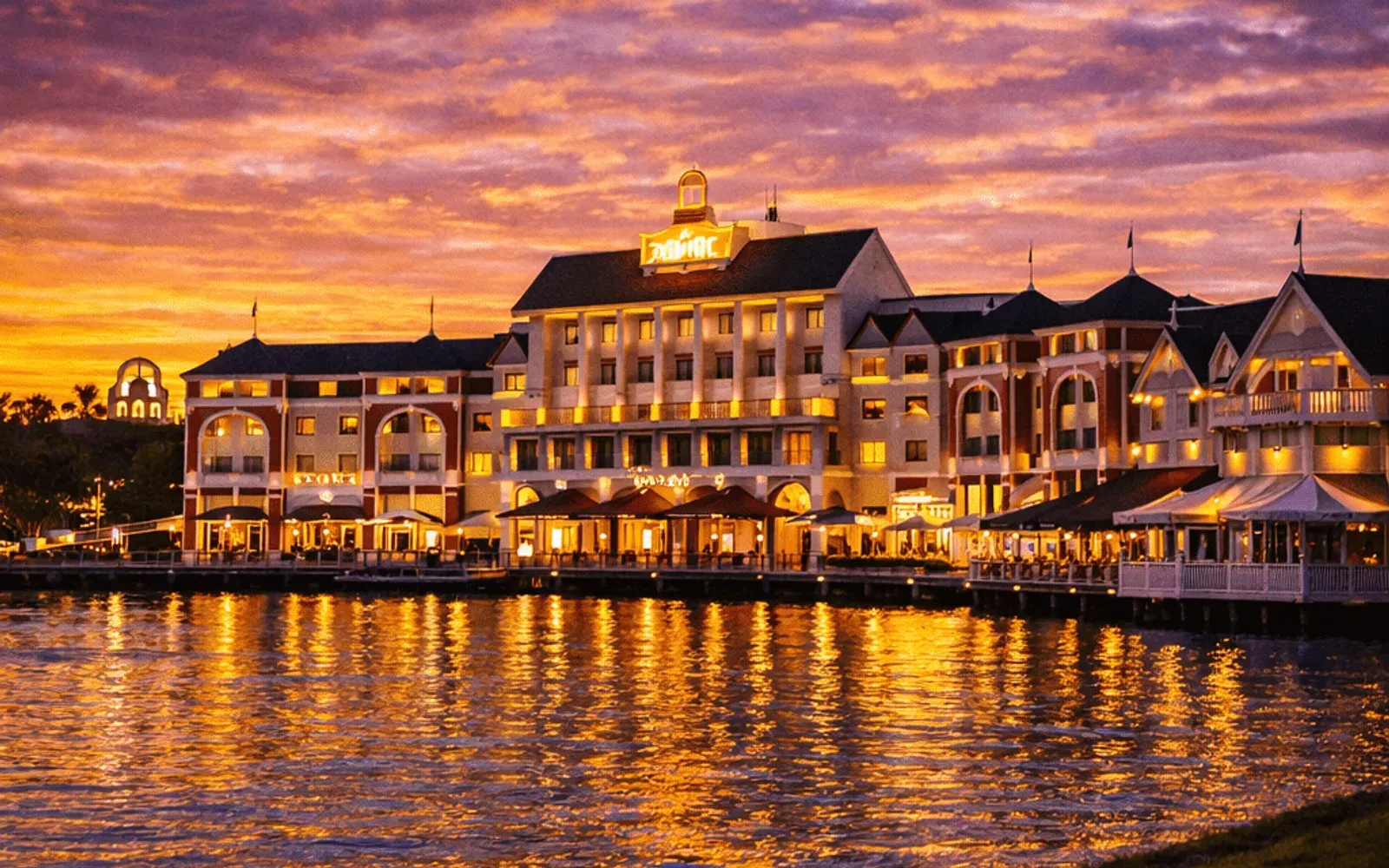 Illustrated sunset view of Disney's BoardWalk Inn across the water.