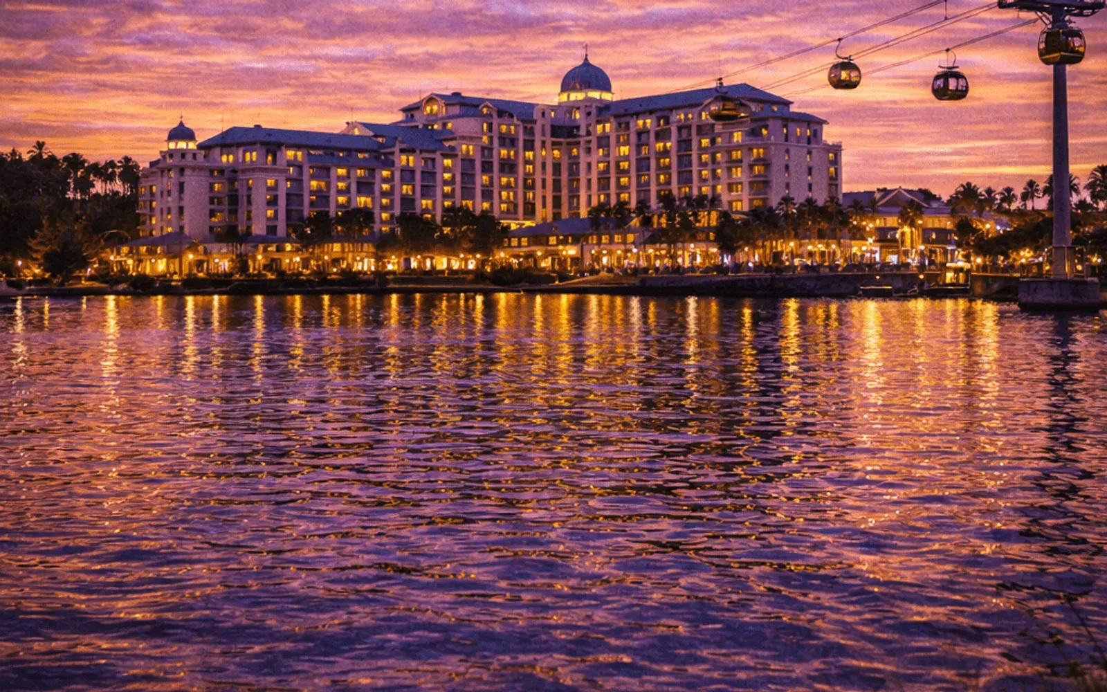 Illustrated sunset view of Disney's Riviera Resort across the water.