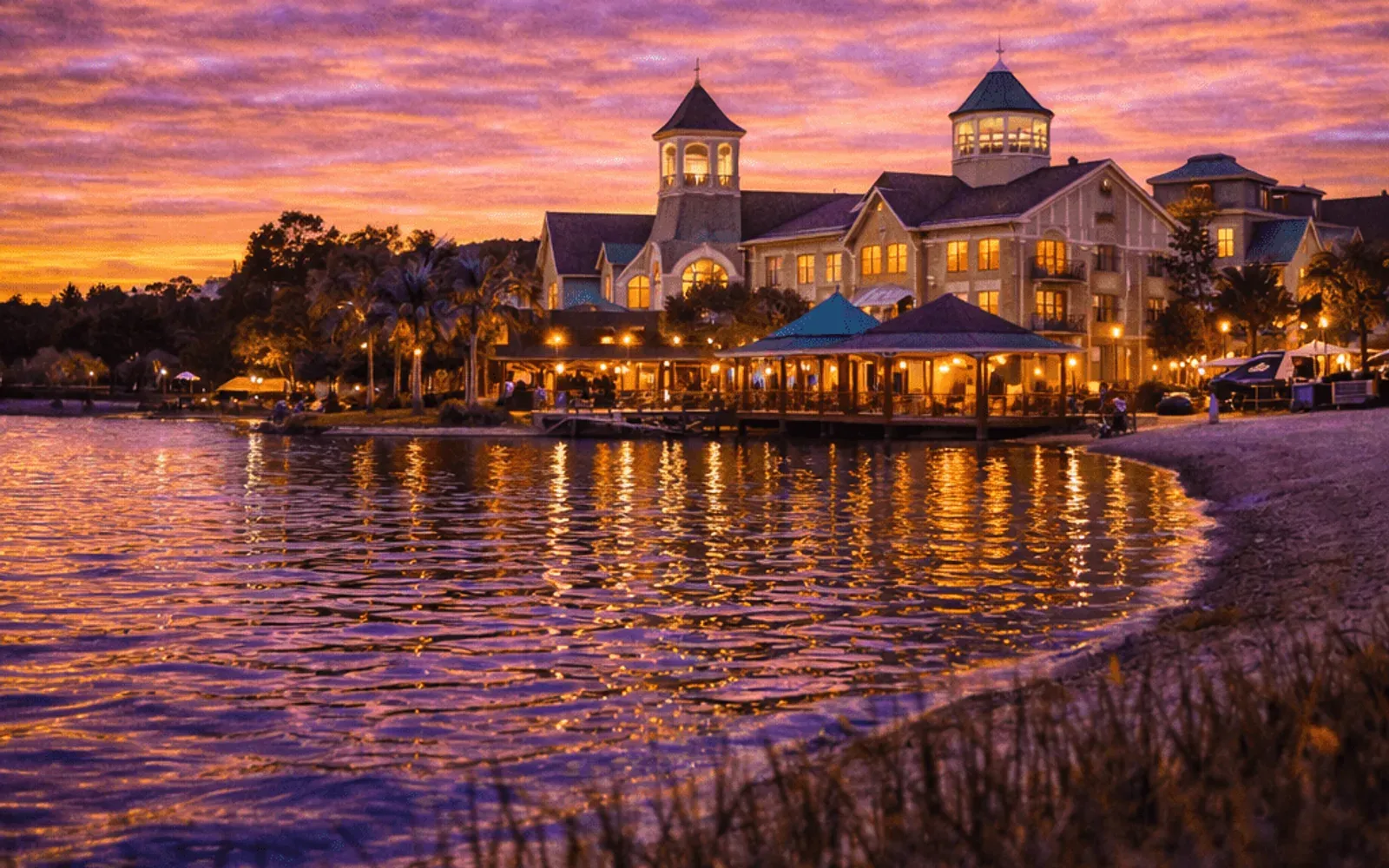Illustrated sunset view of Disney's Saratoga Springs Resort & Spa across the water.