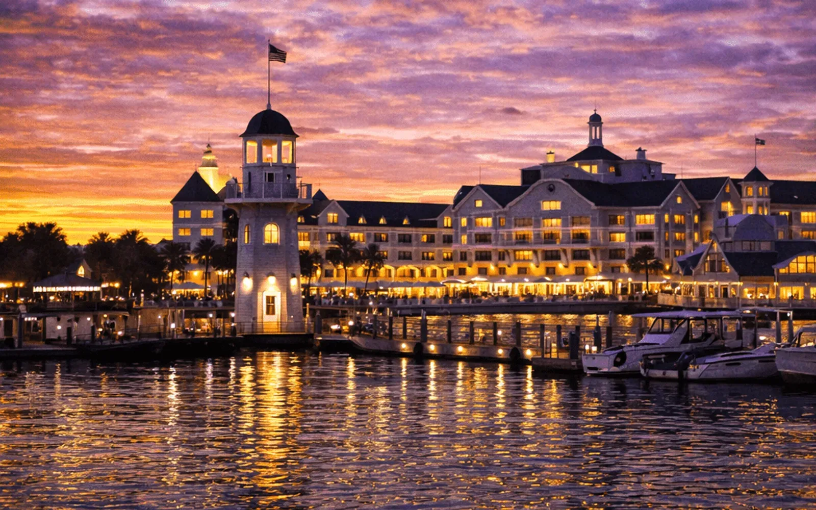 Illustrated sunset view of Disney's Yacht Club Resort across the water.